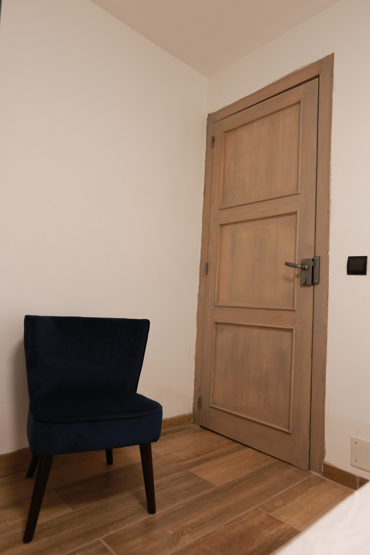 Chambre avec fauteuil et porte en bois massif